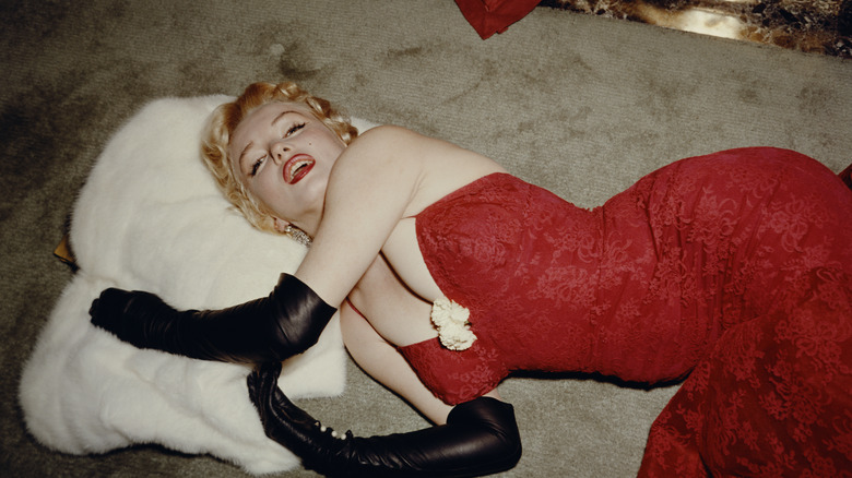 Marilyn Monroe sdraiata con un vestito rosso