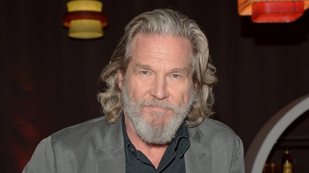 Jeff Bridges con i capelli lunghi e la giacca grigia