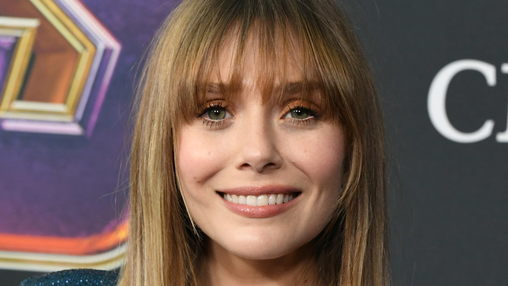 Elizabeth Olsen sorride mentre posa sul tappeto rosso