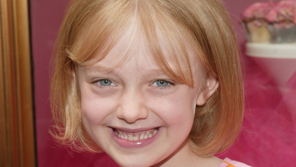 Dakota Fanning, da bambina, 2003, sorridente, frangia e caschetto biondo