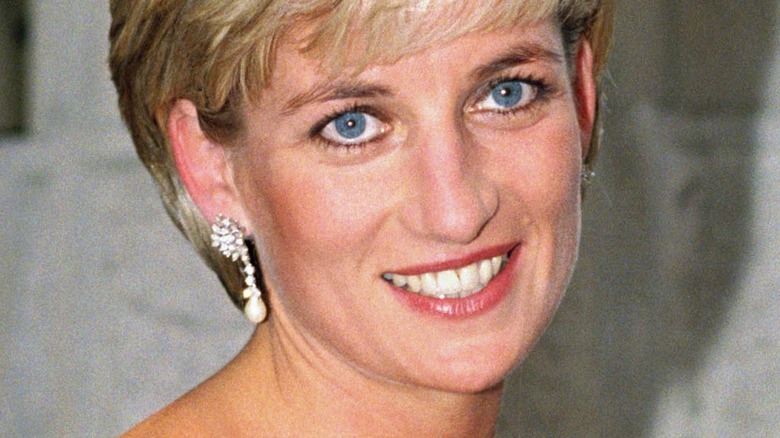 La principessa Diana sorridente con gli orecchini pendenti