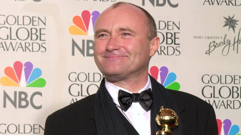 Phil Collins sorride con il premio