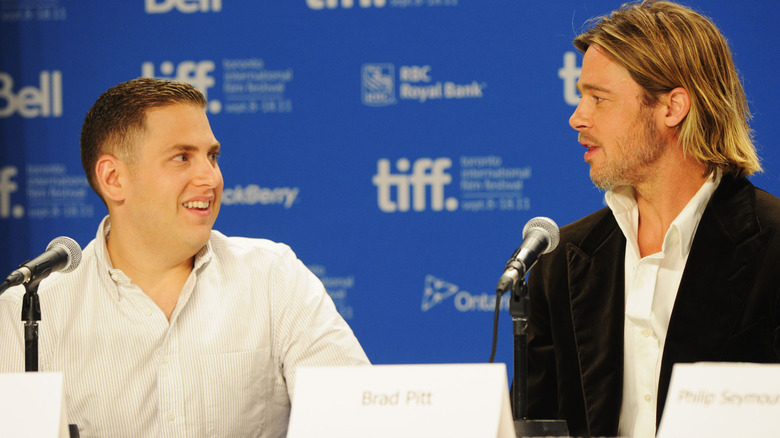 Brad Pitt e Jonah Hill sorridono mentre sono su un pannello