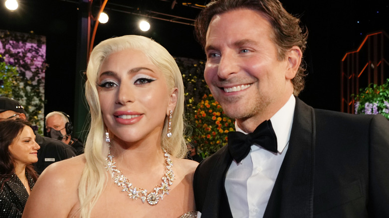 Lady Gaga e Bradley Cooper sorridono durante una cerimonia di premiazione