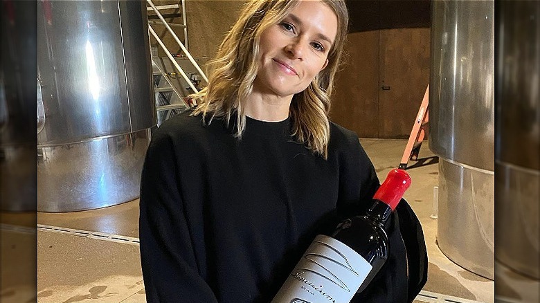 Danica Patrick con in mano una bottiglia di vino