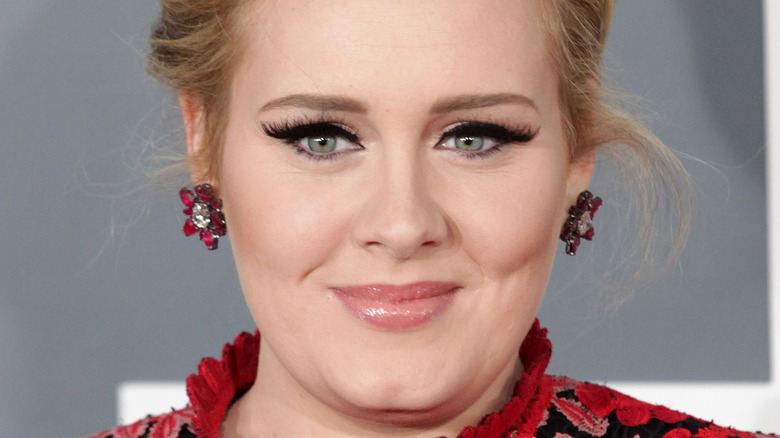 Adele sorridente orecchini rosa rossa eyeliner nero