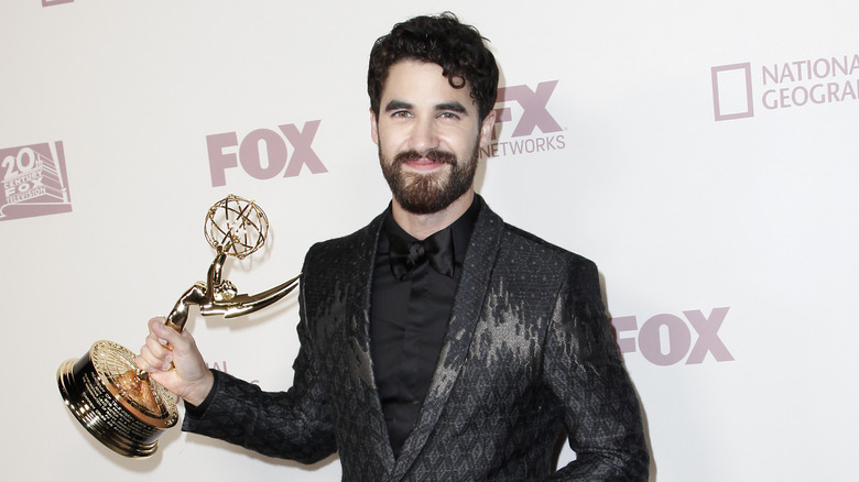 Darren Criss sorridente, con in mano un Emmy Award 