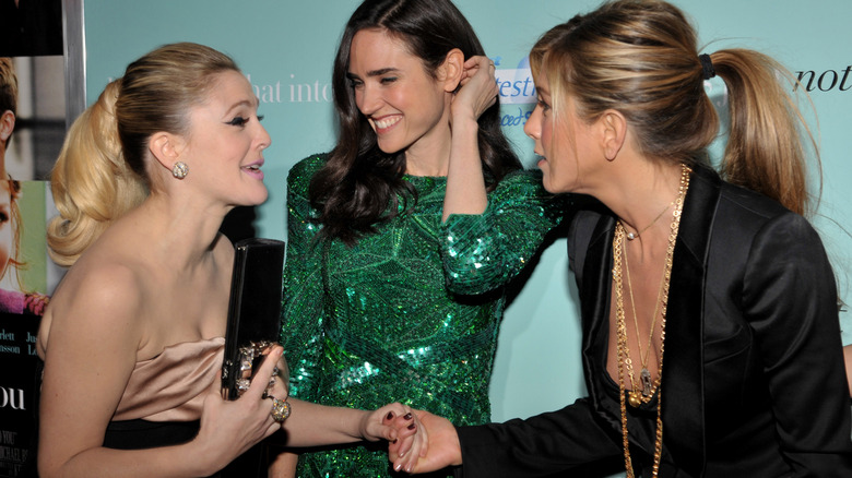 Jennifer Aniston e Drew Barrymore si stringono la mano davanti a Jennifer Connelly