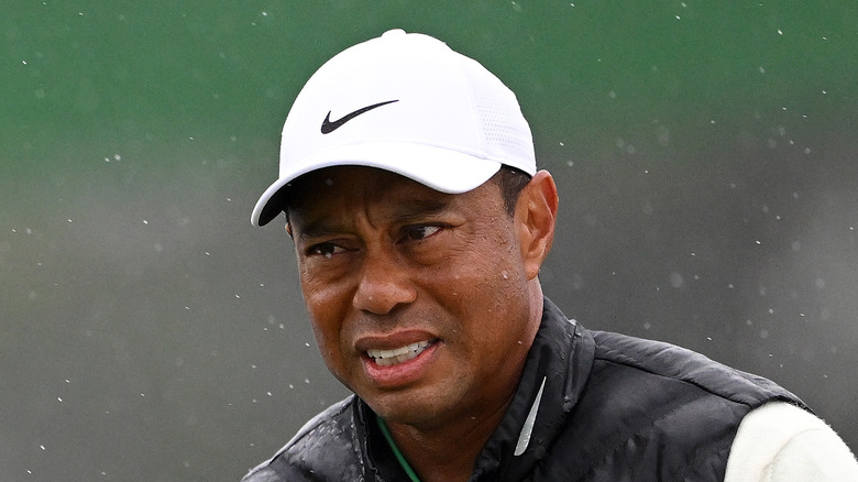 Tiger Woods strizza gli occhi sotto la pioggia